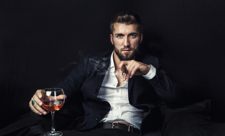 Attraktiver Mann mit Whiskey und Zigarre Ein selbstbewusster Mann mit Whiskey und Zigarre.