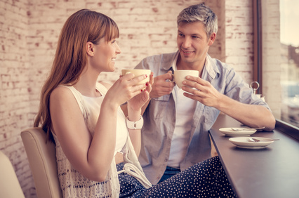 Eine junge Frau und ein Mann trinken Kaffee bei ihrem ersten Date.